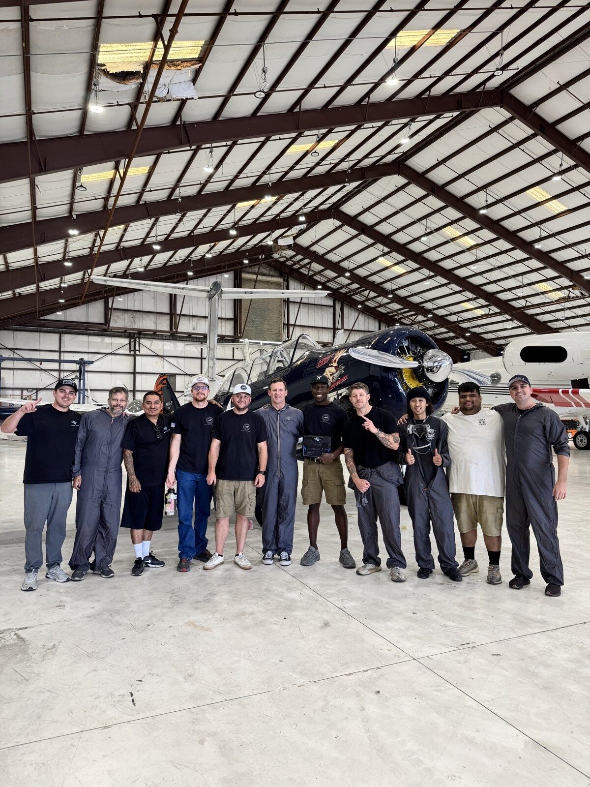 Aircraft detailing class lined up in front of a freshly polished vintage warbird after training